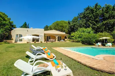 a group of lawn chairs next to a swimming pool at Villa Sounia by Villa Plus in Lagos