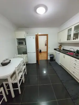 a kitchen with a table and a white refrigerator at Suncoast Residence V (Free parking) in Funchal