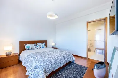 a white bedroom with a bed and a mirror at Sweet Home Sagres in Sagres