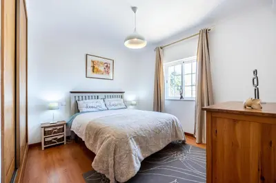 a bedroom with a large bed and a window at Sweet Home Sagres in Sagres