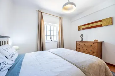 a bedroom with a bed and a dresser and a window at Sweet Home Sagres in Sagres