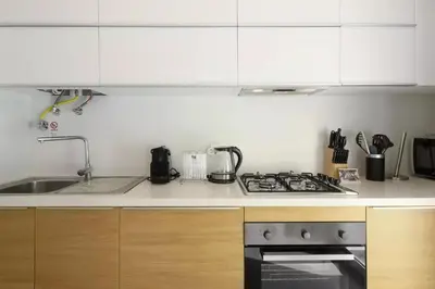 a kitchen with a sink and a stove top oven at 1 Bed Apartment Sleeps 4 with Pool in Funchal