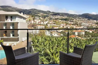 a balcony with chairs and a view of a city at 1 Bed Apartment Sleeps 4 with Pool in Funchal