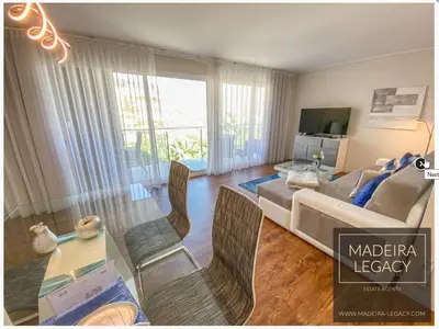 a living room with a couch and a table with chairs at 1 Bed Apartment Sleeps 4 with Pool in Funchal