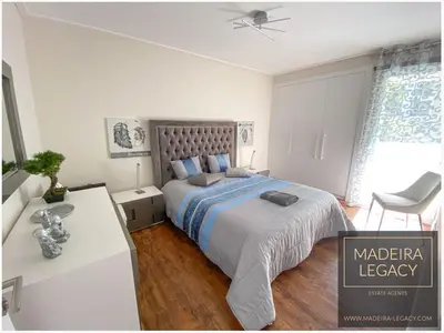 a bedroom with a bed and a table and a chair at 1 Bed Apartment Sleeps 4 with Pool in Funchal
