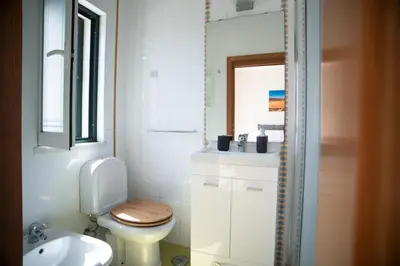 a white bathroom with a toilet and a sink at Kichershome in Sagres