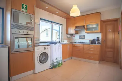 a kitchen with a washing machine and a washer at Kichershome in Sagres