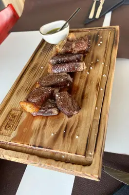 a wooden cutting board with some meat on it at Magnólia Mar Senses in Lagos