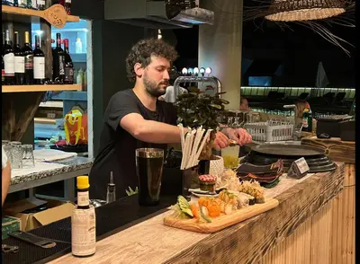 a man standing behind a counter preparing food at Magnólia Mar Senses in Lagos
