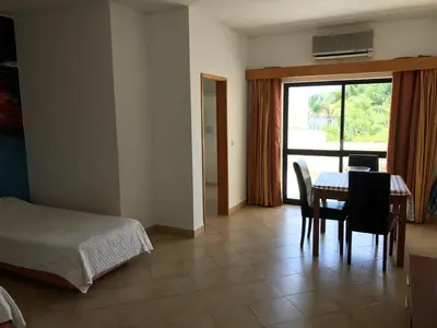 a bedroom with a bed and a table and chairs at Magnólia Mar Senses in Lagos