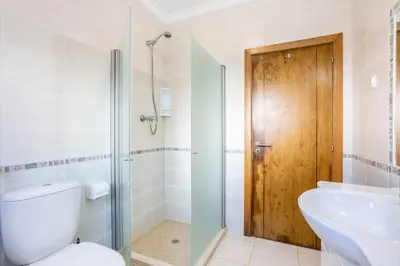 a bathroom with a toilet and a sink and a shower at Villa Flavia in Aljezur