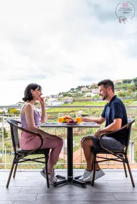 a man and a woman sitting at a table at La Chambre Rose in Ponta do Sol