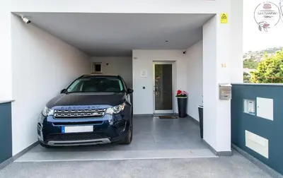 a car parked in a garage next to a door at La Chambre Rose in Ponta do Sol