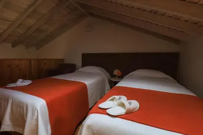 two beds with white shoes on them in a room at QUINTA DO FALCÃO in Almagreira