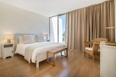 a white bedroom with a bed and a window at Blue Villa H - Sagres - 10 min walk to the beach in Sagres