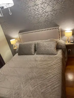 a bedroom with a large bed with two lamps at Ajuda Paradise apartment with pool and private parking in Funchal