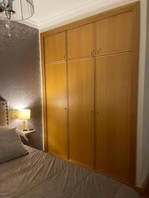 a bedroom with a large wooden cabinet next to a bed at Ajuda Paradise apartment with pool and private parking in Funchal