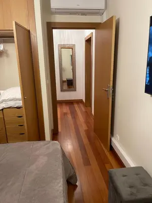 a bedroom with a bed and a hallway with a mirror at Ajuda Paradise apartment with pool and private parking in Funchal
