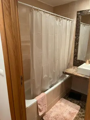 a bathroom with a shower curtain and a sink at Ajuda Paradise apartment with pool and private parking in Funchal
