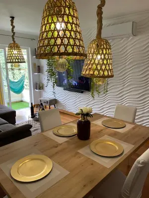 a dining room table with yellow plates and chandeliers at Ajuda Paradise apartment with pool and private parking in Funchal