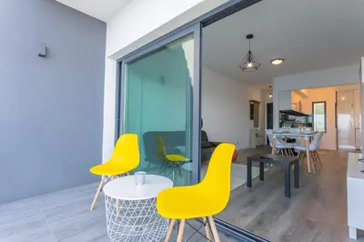 a living room with yellow chairs and a table at FLH Fantastic Ocean View with Balcony in Santa Cruz