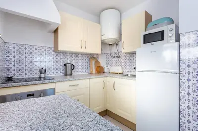 a kitchen with white cabinets and a white refrigerator at Apartamento Salema 33 in Salema