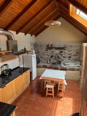 a kitchen with a table and a stove and a table at Cozy Sea View House Fajã da Ovelha in Calheta