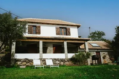 a house with two chairs in front of it at Cozy Sea View House Fajã da Ovelha in Calheta