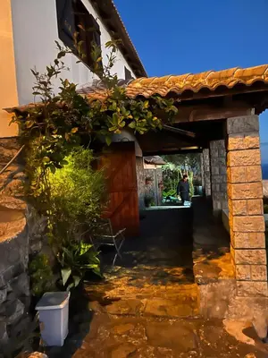 a house with a wooden door and some plants at Cozy Sea View House Fajã da Ovelha in Calheta