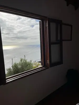 a window in a room with a view of the ocean at Cozy Sea View House Fajã da Ovelha in Calheta