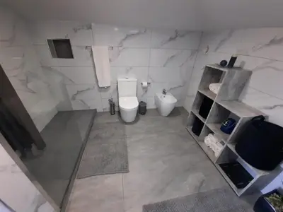 a white bathroom with a toilet and a sink at Zeza´s Sky in Calheta