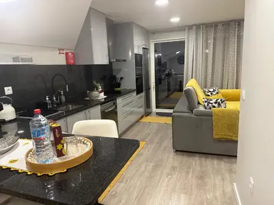 a kitchen and living room with a couch and a table at Zeza´s Sky in Calheta