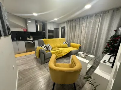 a living room with a yellow couch and a kitchen at Zeza´s Sky in Calheta