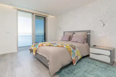 a bedroom with a large bed and a large window at Sonho do Oceano in Ribeira Brava