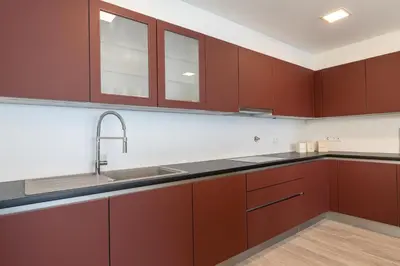 a kitchen with red cabinets and a sink at Sonho do Oceano in Ribeira Brava