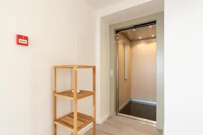 a hallway with a wooden book shelf next to a door at Sonho do Oceano in Ribeira Brava