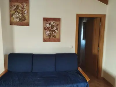 a blue bed in a room with two paintings on the wall at Coureladaltura in Aljezur