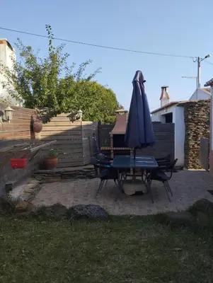 a patio with a table and an umbrella at Coureladaltura in Aljezur