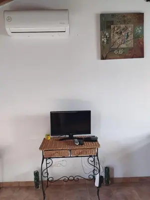a room with a table with a television and a fan at Coureladaltura in Aljezur