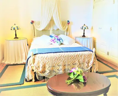a bedroom with a bed with a table and two lamps at Quinta do Cabouco in Ribeira Brava