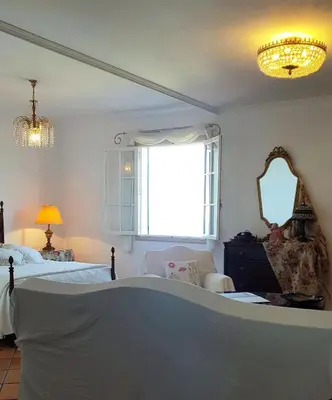 a bedroom with two beds and a large window at Quinta do Cabouco in Ribeira Brava