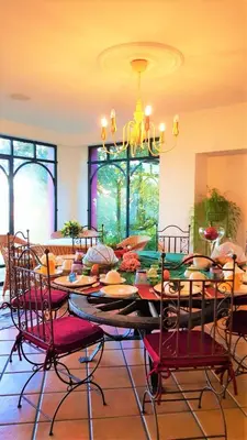 a dining room with a table with chairs and a chandelier at Quinta do Cabouco in Ribeira Brava