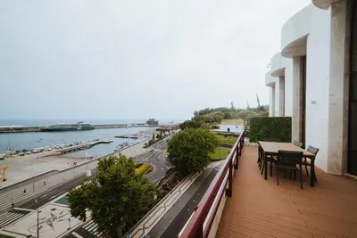 a balcony with tables and chairs and a view of a river at Rooftop Marina ll by Madeira Best Apartments in Funchal