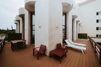 a balcony with chairs and tables on a building at Rooftop Marina ll by Madeira Best Apartments in Funchal
