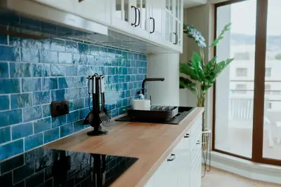 a kitchen with blue tile on the wall at Rooftop Marina ll by Madeira Best Apartments in Funchal