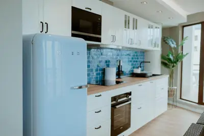 a blue refrigerator in a kitchen with white cabinets at Rooftop Marina ll by Madeira Best Apartments in Funchal