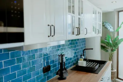 a kitchen with blue tile on the wall at Rooftop Marina ll by Madeira Best Apartments in Funchal
