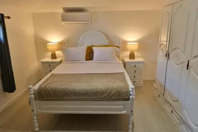 a bedroom with a white bed with two lamps at Sebastian's Apartment in São Vicente