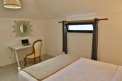 a bedroom with a bed and a desk with a laptop at Sebastian's Apartment in São Vicente
