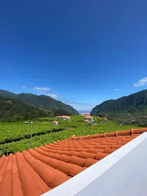 a roof of a building with mountains in the background at Sebastian's Apartment in São Vicente